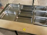 a table with six trays of food on it