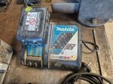 une photo d'une perceuse Makita et d'autres outils posés sur un établi