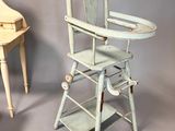 a baby high chair next to a piano on a grey background