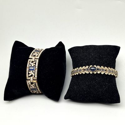 une paire de coussins en velours noir ornés de perles dorées et bleues