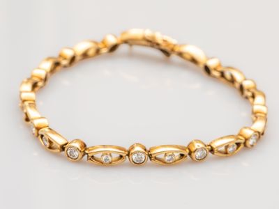 a close up of a gold bracelet with diamonds on it