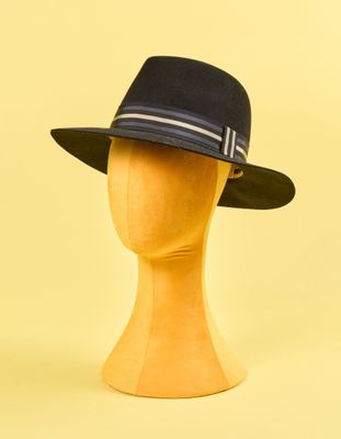 chapeau posé sur une tête de mannequin, sur fond jaune