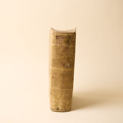 un vieux livre posé sur une table sur une surface blanche