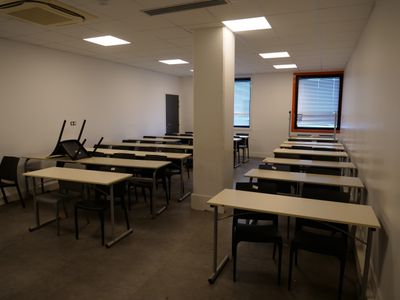 many tables and chairs in a room with a window