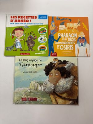 trois livres pour enfants sont posés sur une surface blanche
