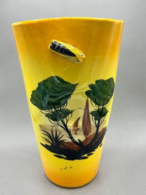 a yellow vase with a picture of a bird on it