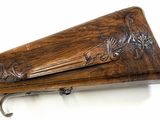 a close up of a rifle with a wooden case on a white background