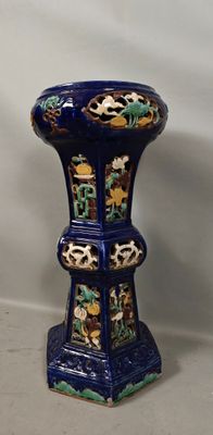 un vase bleu orné d'un motif, posé sur une table