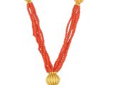 une image représentant un collier rouge orné de perles dorées et d'un pompon