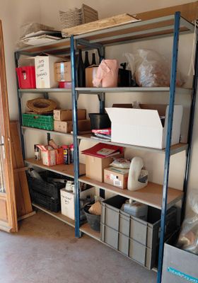 a room that has a shelf with boxes and boxes on it