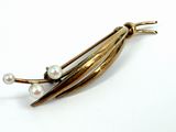 an image of a close up of a brooch with pearls on it