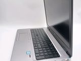 a silver laptop with a black keyboard on a white surface