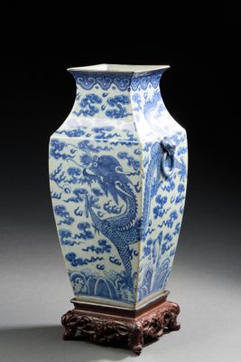 vase bleu et blanc orné d'un dragon, posé sur un socle