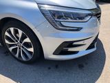 the front end of a silver car parked in a parking lot