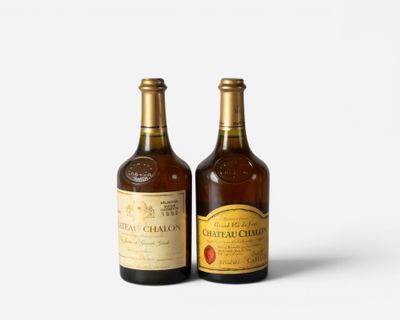 two bottles of wine sitting next to each other on a white surface