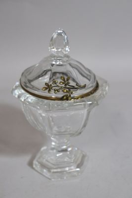 a small glass bowl with a lid on a white surface