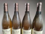 four bottles of wine are lined up on a table