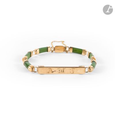 a gold and green bracelet with an engraved bar on it