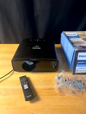 un petit projecteur posé sur une table à côté d'une télécommande