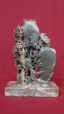 une statue représentant un vase sur lequel est posé un oiseau