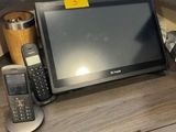 a desk with a laptop, phone, and other items on it
