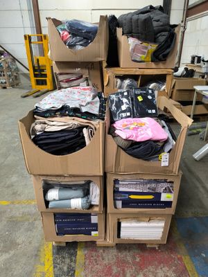 Des cartons de vêtements sont empilés les uns sur les autres dans un entrepôt