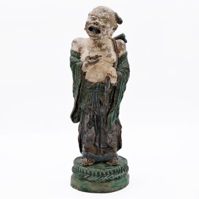 an old statue of a man holding a bird on a pedestal