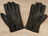 pair of black leather gloves on a wooden surface