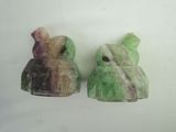 two pieces of green and purple marble sitting on top of a white surface