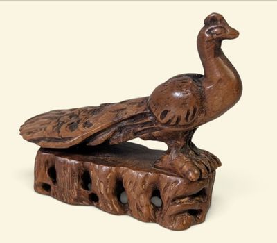 une sculpture en bois représentant un oiseau perché sur un morceau de bois
