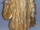 statue d'un homme vêtu d'une robe dorée et tenant une cigarette
