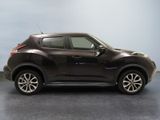 the front view of a brown nissan juke suv parked in a garage