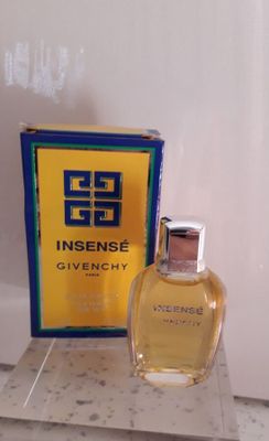 un flacon de parfum Givenchy posé à côté d'une boîte de parfum sur un comptoir