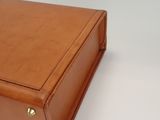 a brown leather case sitting on top of a white table