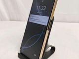 a close up of a cell phone on a stand on a white surface