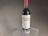a bottle of wine sitting on top of a clear box