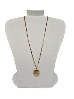 un torse de mannequin blanc orné d'un collier et d'une chaîne dorés