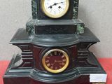 une horloge noire posée sur une table rouge