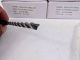 a person holding a drill in front of a box of drill bits
