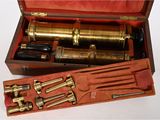 une boîte en bois contenant un télescope en laiton