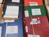many folders of papers on a table with a red table cloth