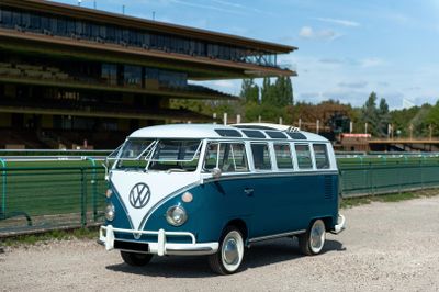 a blue and white vw bus parked on the side of the road