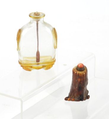 une petite bouteille en verre munie d'une poignée en bois, à côté d'une autre petite bouteille en verre munie d'une poignée en bois