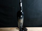 une photo en noir et blanc d'un aspirateur posé sur une table en bois