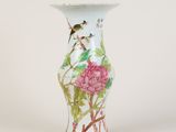 un vase blanc orné d'une fleur rose et d'oiseaux