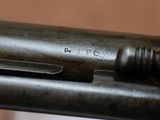 close up of a gun with a metal barrel on a wooden table