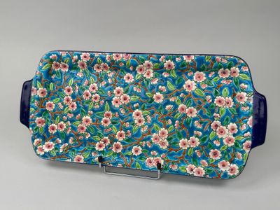 un plateau à motifs floraux bleu et rose, muni d'anses