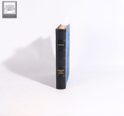 a black book sitting on top of a white table next to a white wall