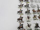 many figurines of people riding horses on a white surface