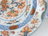 a plate with a floral design on it on a stand